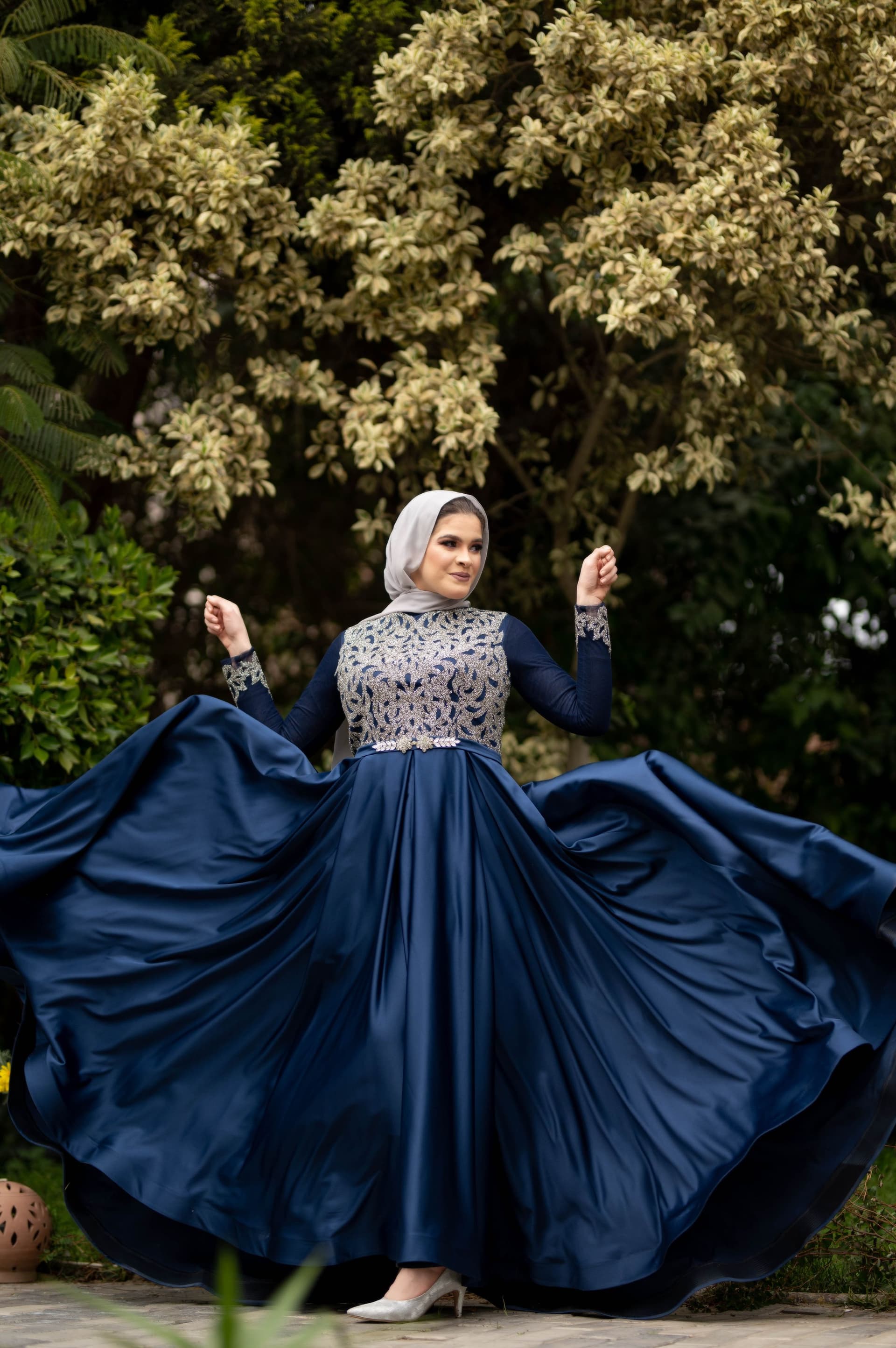 Navy satin ball gown with full skirt spread out as the model turns